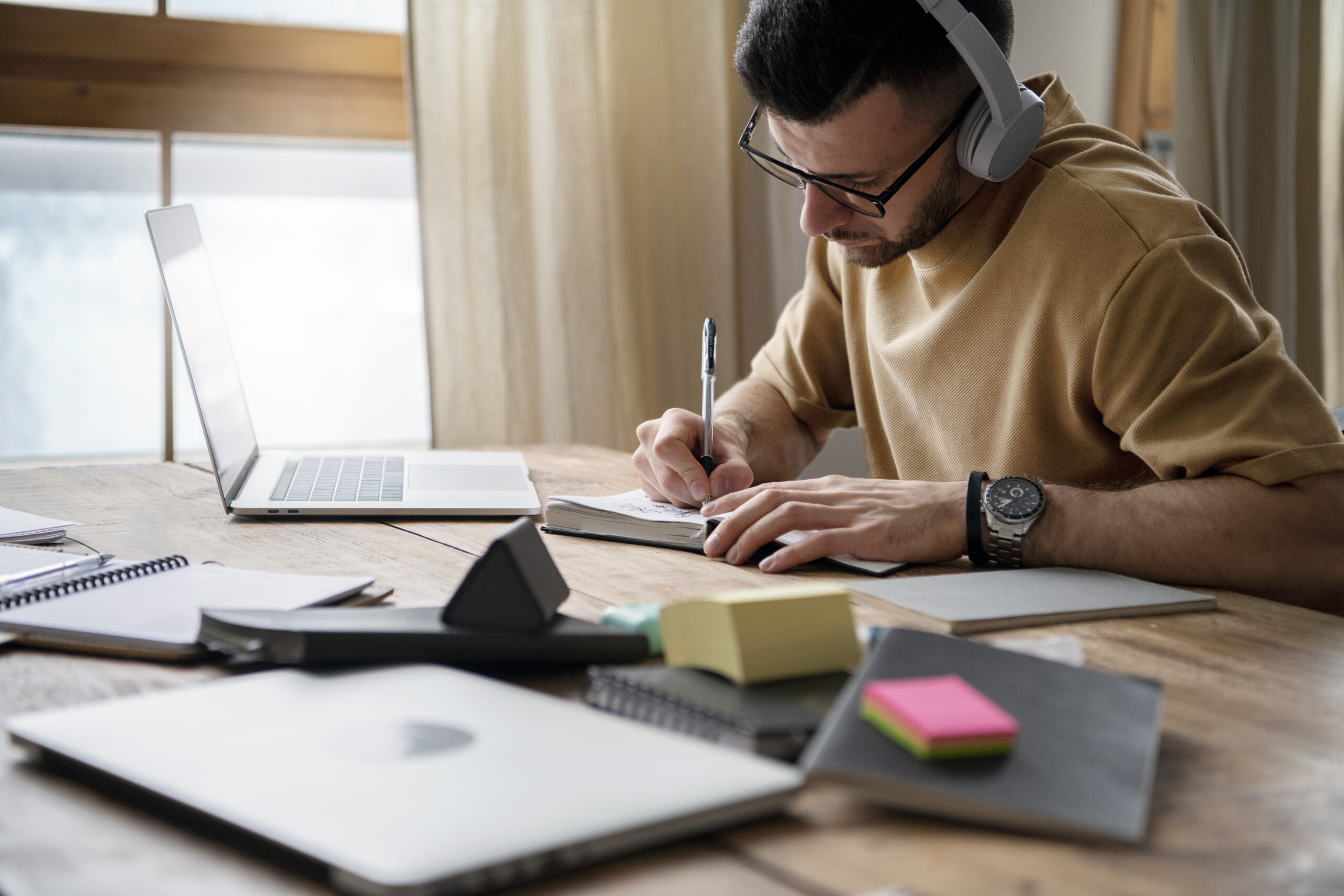 young man writing notebook study session